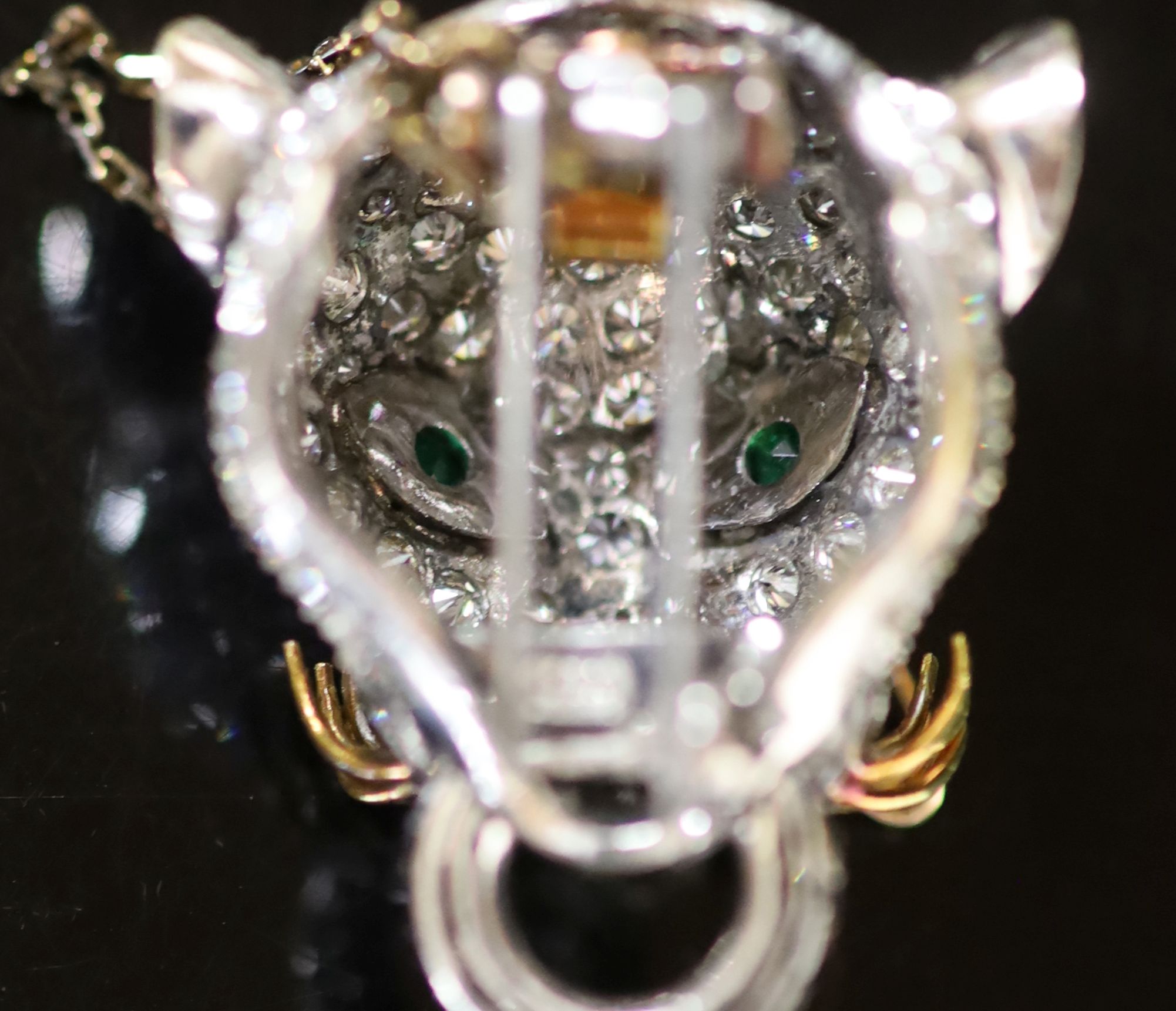 An 18K white gold and diamond leopard's head clip brooch, with emerald eyes, ruby nose and gold whiskers,